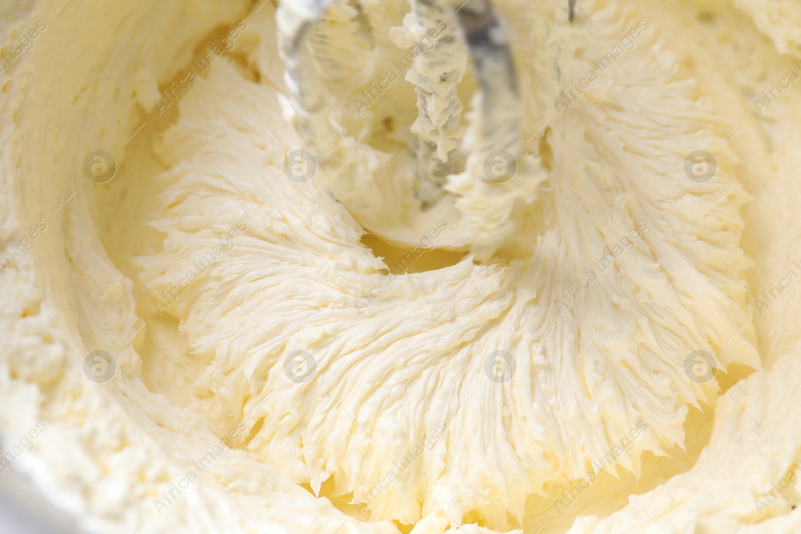 Photo of Mixing whipped cream in bowl with stand mixer, closeup