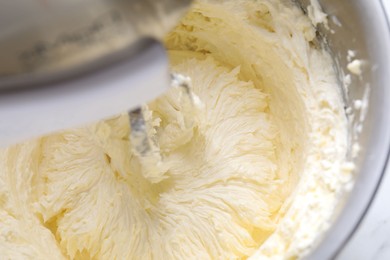 Photo of Mixing whipped cream in bowl with stand mixer, closeup