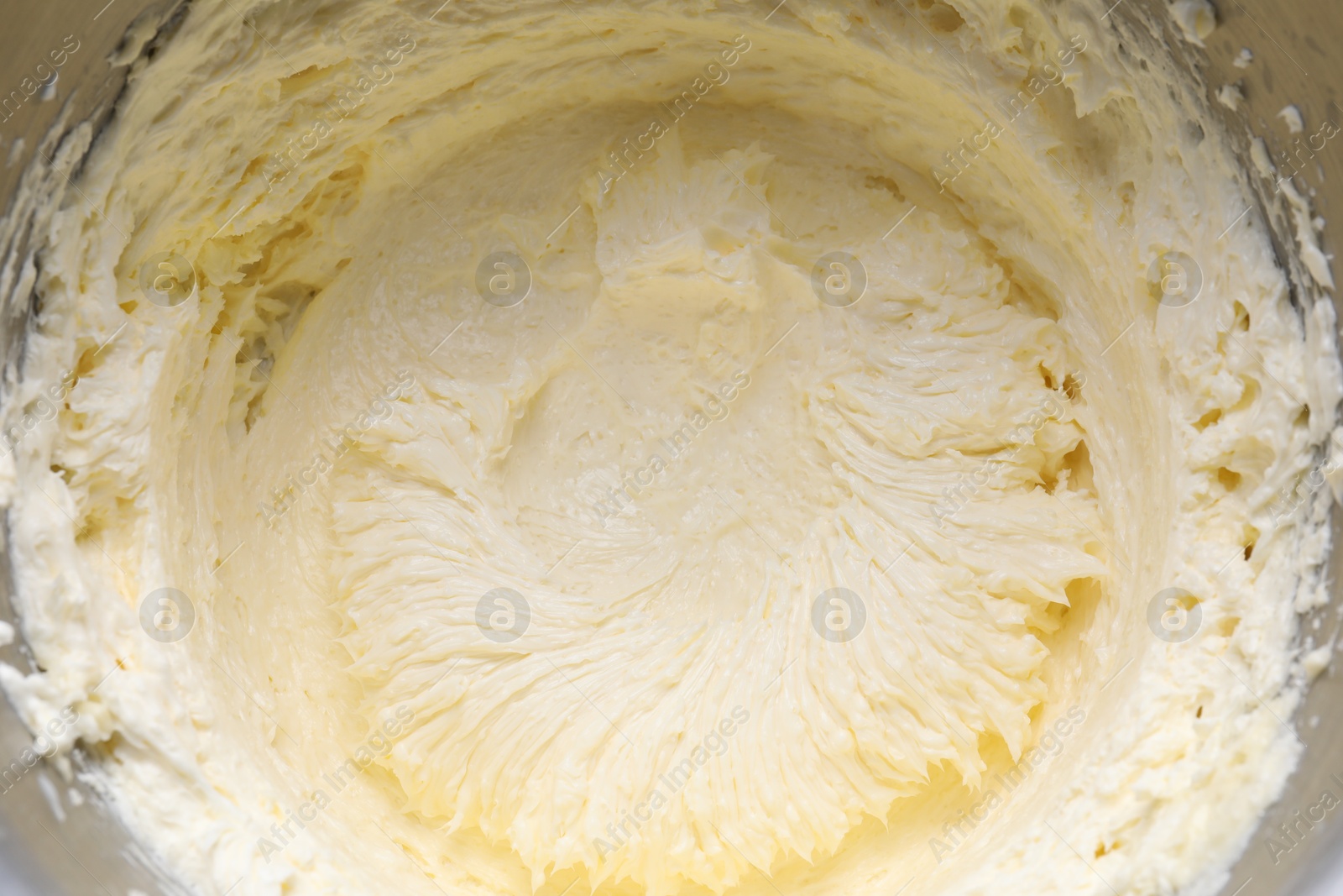 Photo of Delicious whipped cream in metal bowl, top view