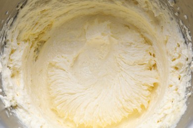 Photo of Delicious whipped cream in metal bowl, top view