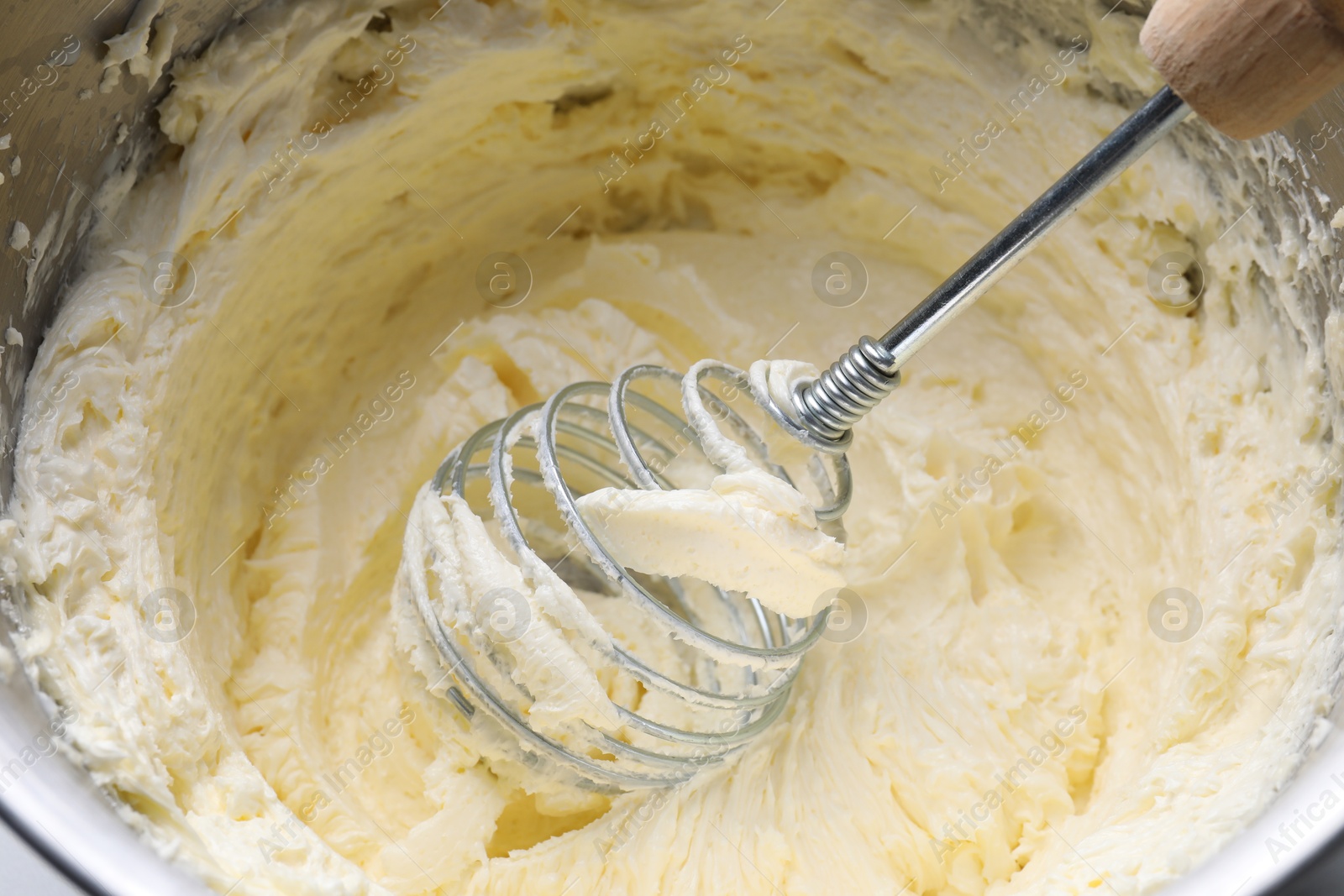 Photo of Whisking whipped cream in bowl, closeup view