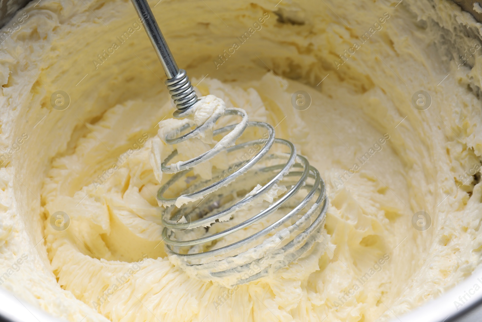 Photo of Whisking whipped cream in bowl, closeup view