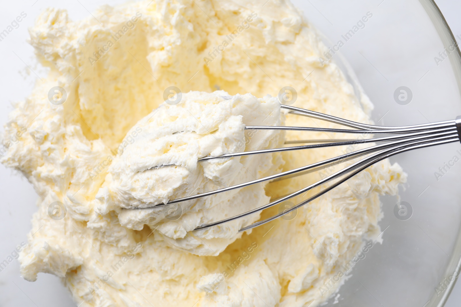 Photo of Bowl with whisk and whipped cream on white table, top view