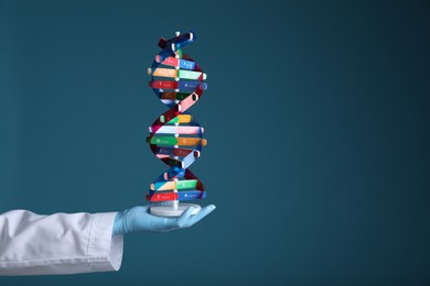 Photo of Scientist holding DNA structure model on dark blue background, closeup. Space for text