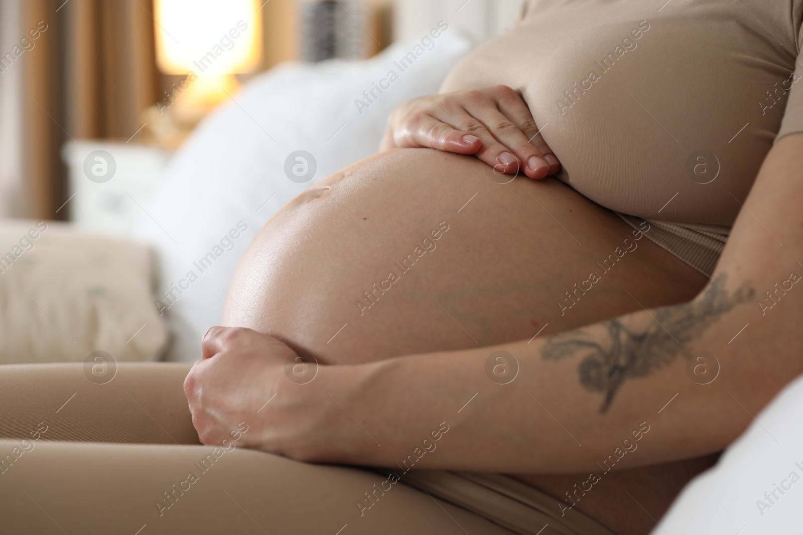 Photo of Pregnant woman on bed at home, closeup