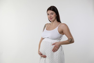 Photo of Beautiful pregnant woman with cute belly on white background