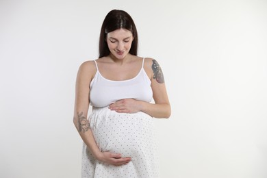 Photo of Beautiful pregnant woman with cute belly on white background