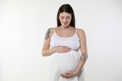 Photo of Beautiful pregnant woman with cute belly on white background