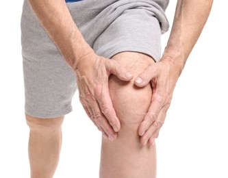 Senior man suffering from knee pain on white background, closeup