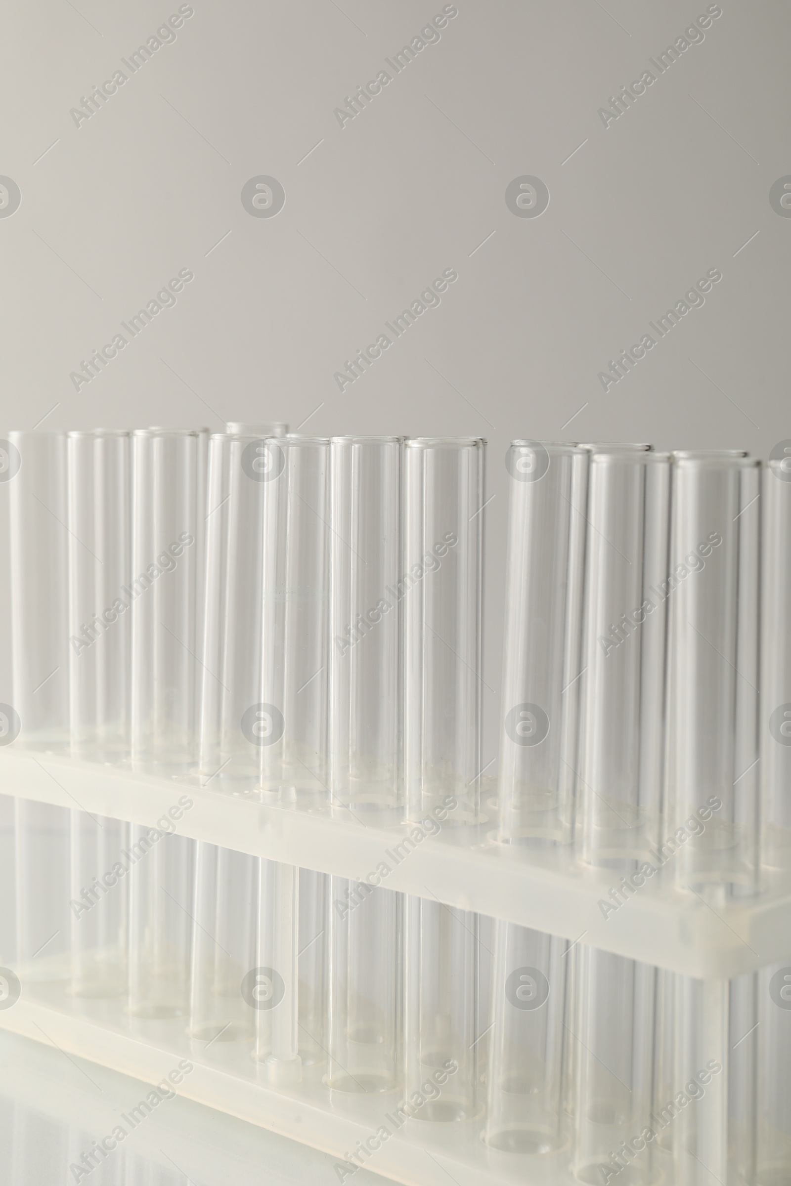 Photo of Empty test tubes on light background, closeup with space for text. Laboratory glassware