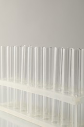 Photo of Empty test tubes on light background, closeup with space for text. Laboratory glassware