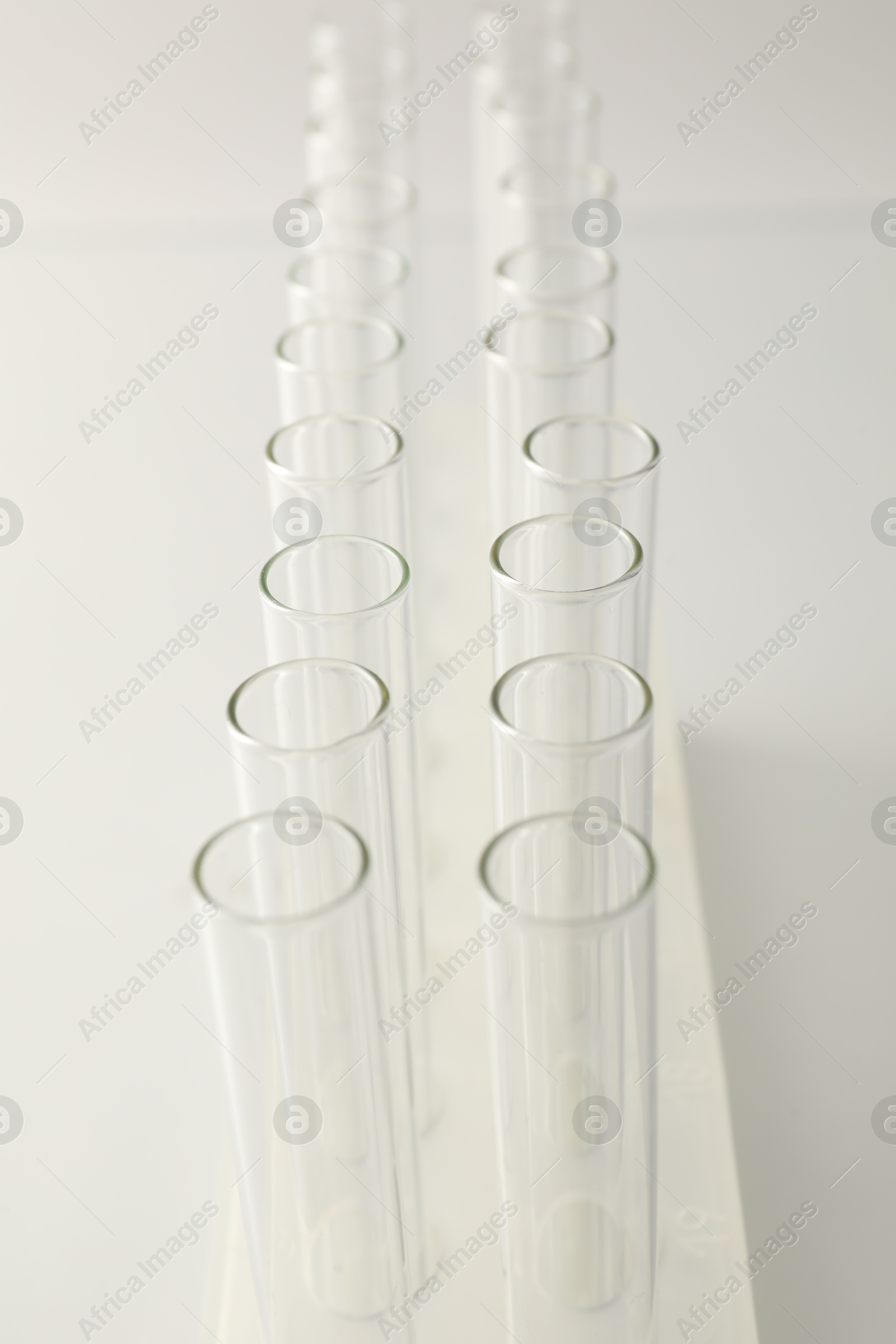 Photo of Empty test tubes on light background, closeup. Laboratory glassware