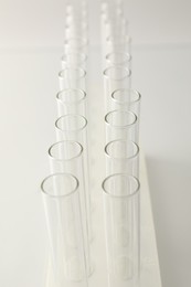 Photo of Empty test tubes on light background, closeup. Laboratory glassware