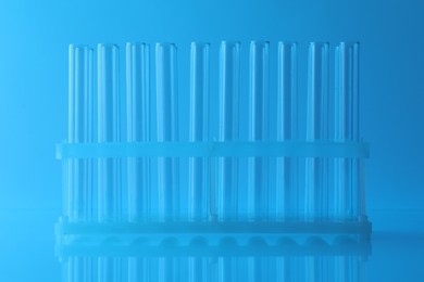 Photo of Empty test tubes on light blue background. Laboratory glassware