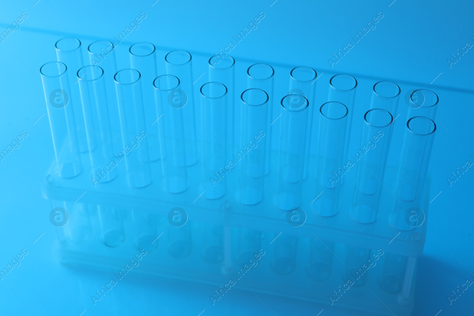 Photo of Empty test tubes on light blue background. Laboratory glassware