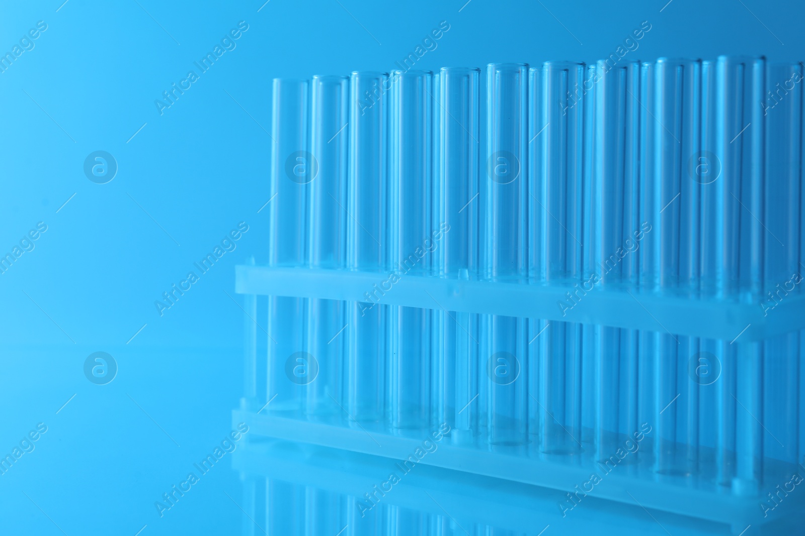 Photo of Empty test tubes on light blue background. Laboratory glassware