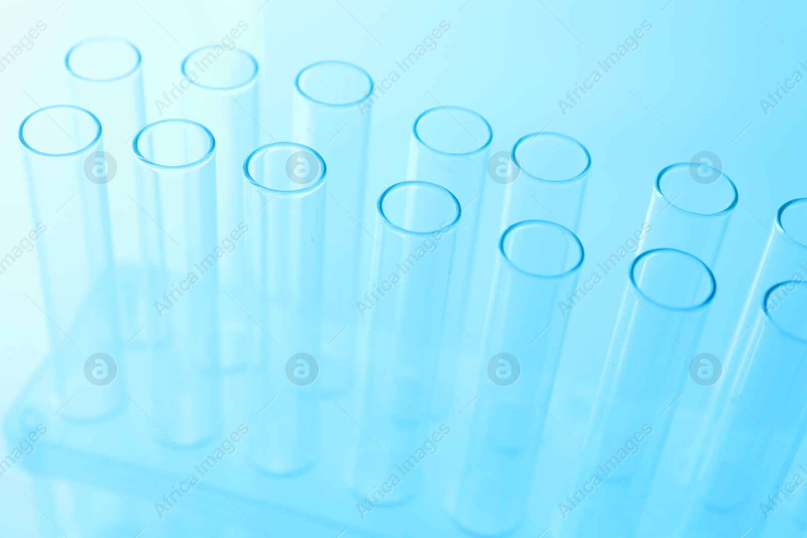 Photo of Empty test tubes on light blue background, closeup. Laboratory glassware