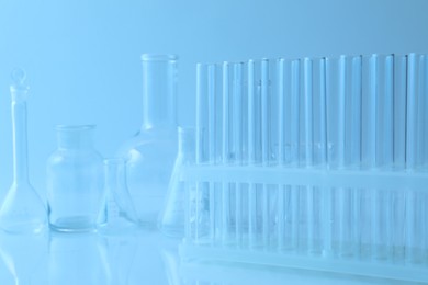 Photo of Different laboratory glassware on light blue background