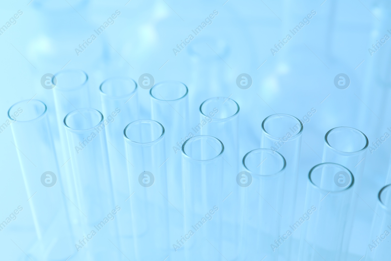 Photo of Empty test tubes on light blue background, closeup. Laboratory glassware