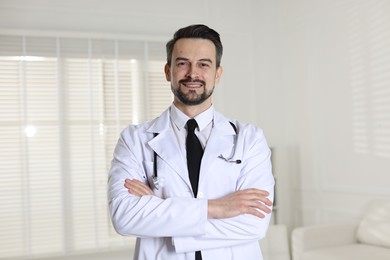 Photo of Portrait of smiling cardiologist with crossed arms in clinic