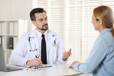 Photo of Cardiologist consulting patient at table in clinic