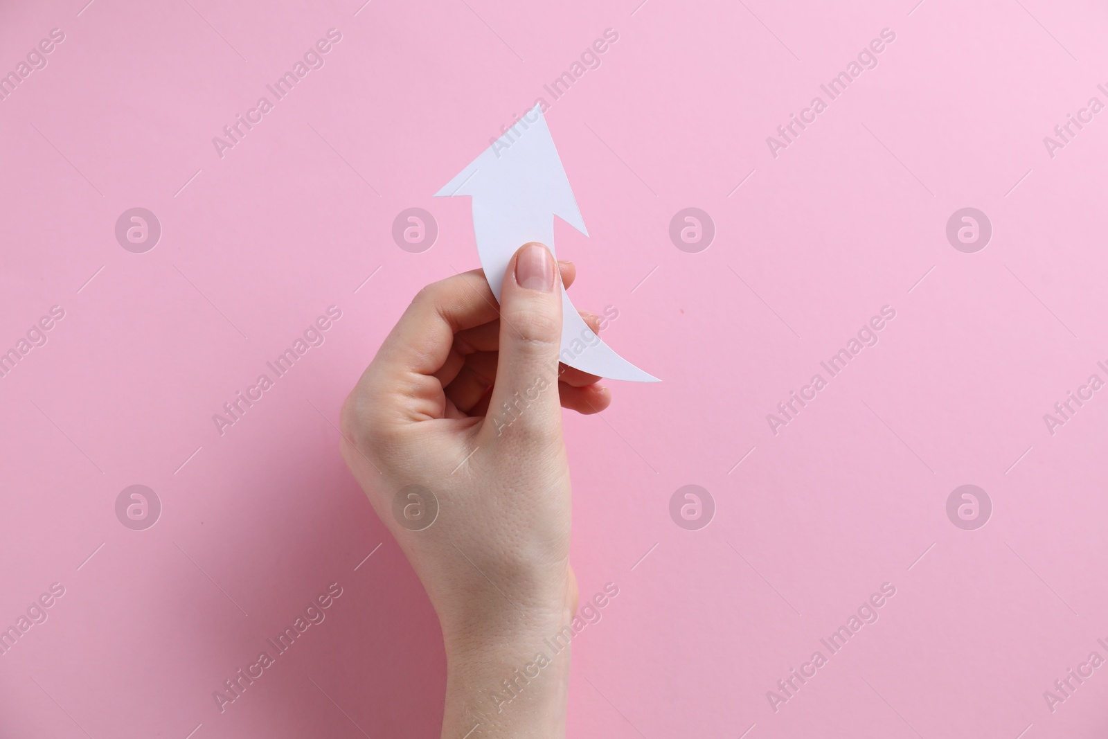 Photo of Woman with paper arrow on pink background, top view. Space for text