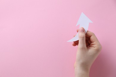 Photo of Woman with paper arrow on pink background, top view. Space for text