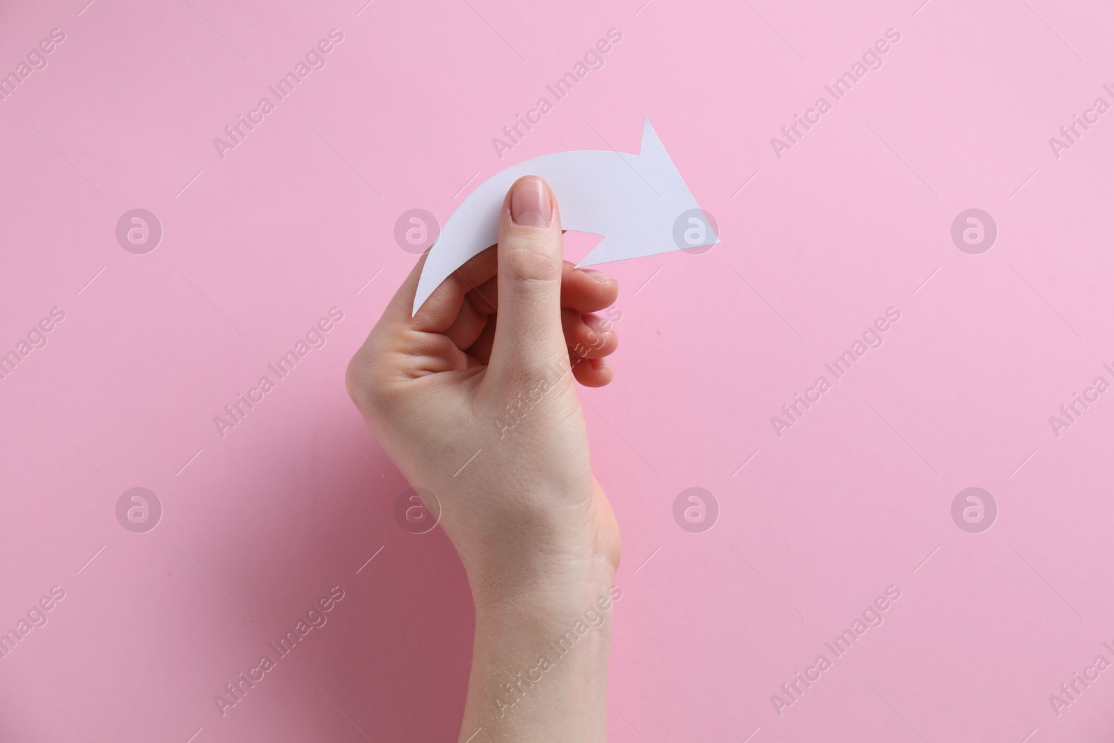 Photo of Woman with paper arrow on pink background, top view