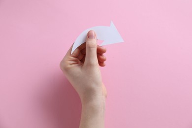 Photo of Woman with paper arrow on pink background, top view