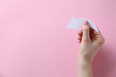 Photo of Woman with paper arrow on pink background, top view. Space for text