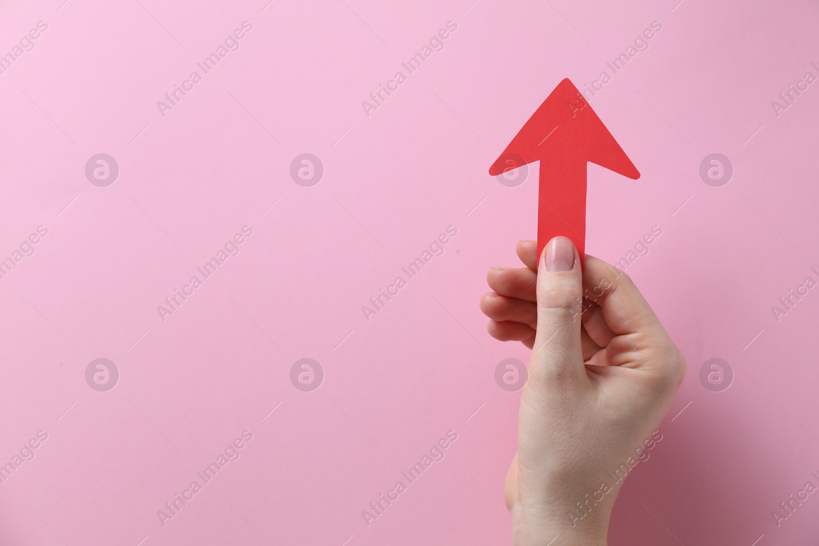 Photo of Woman with paper arrow on pink background, top view. Space for text