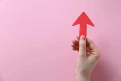 Photo of Woman with paper arrow on pink background, top view. Space for text