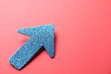 Photo of One glitter arrow on red background, closeup. Space for text