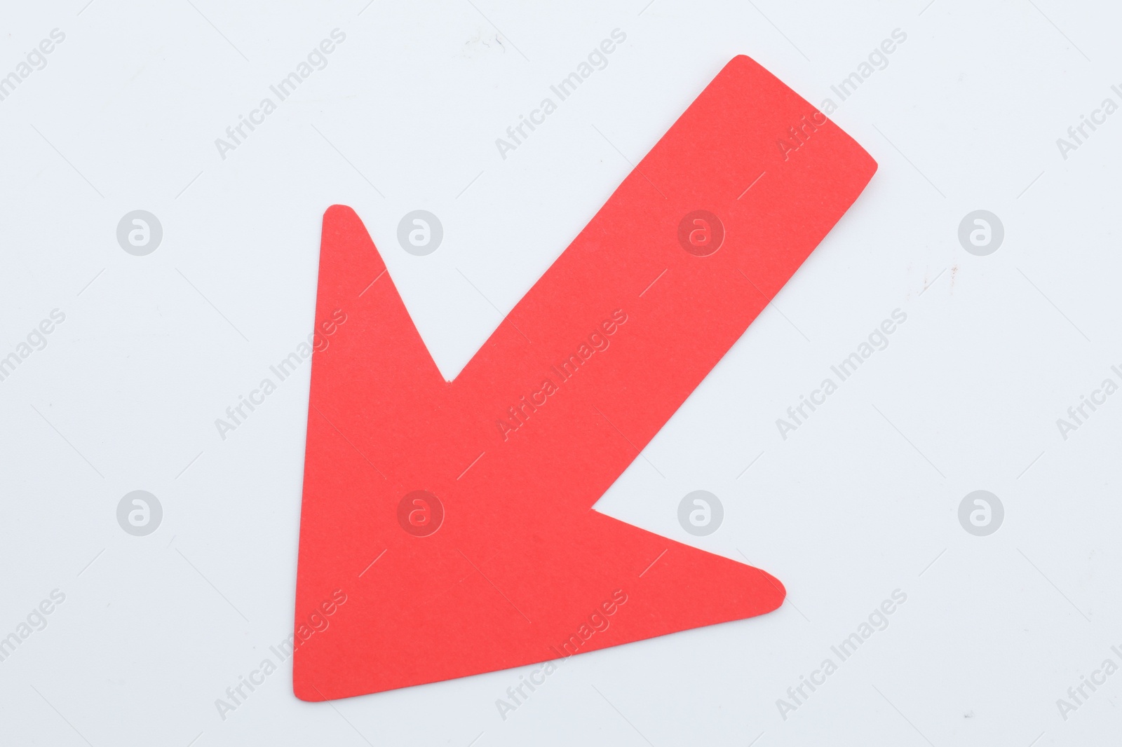 Photo of One red paper arrow isolated on white