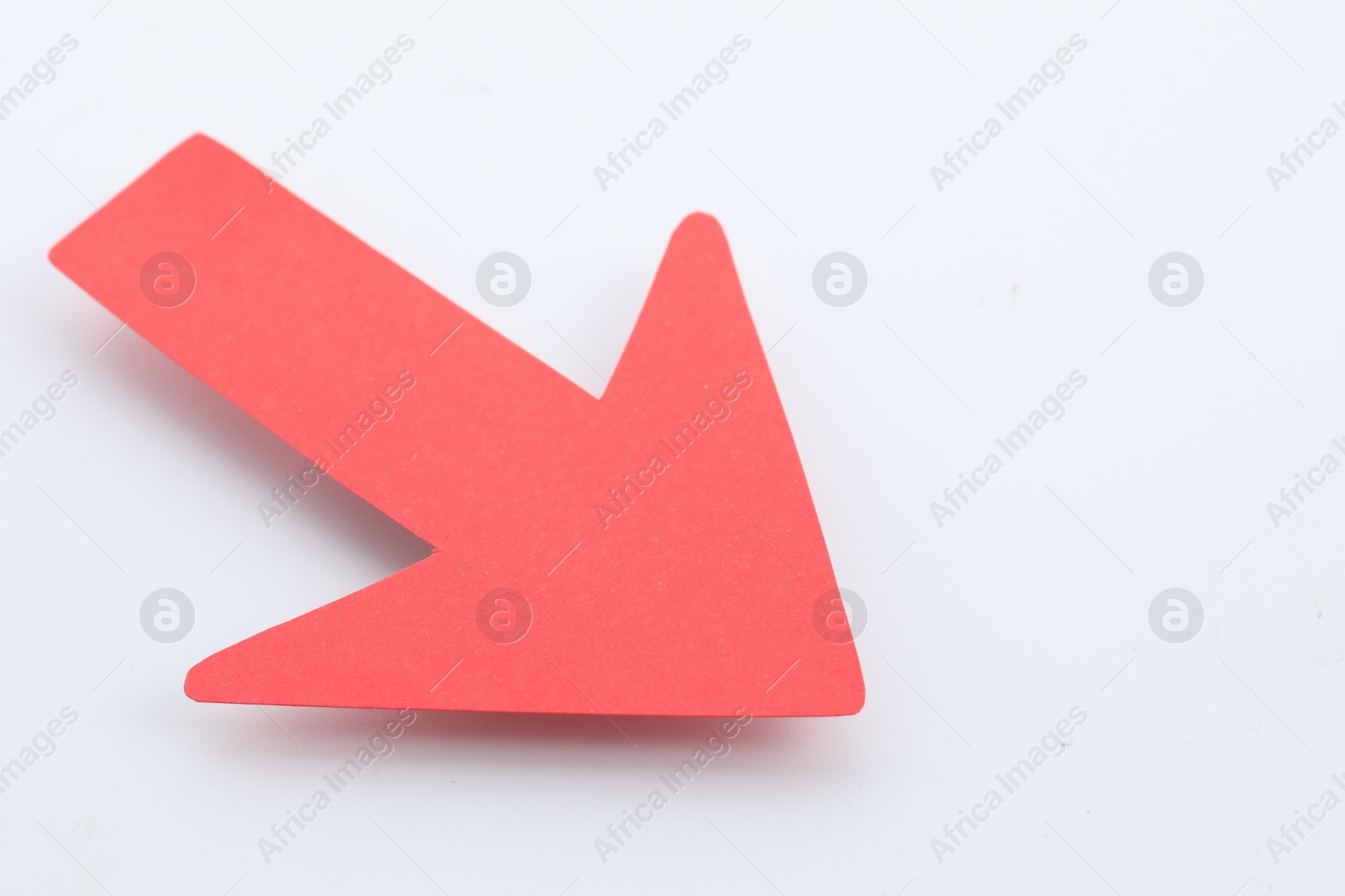 Photo of One red paper arrow isolated on white