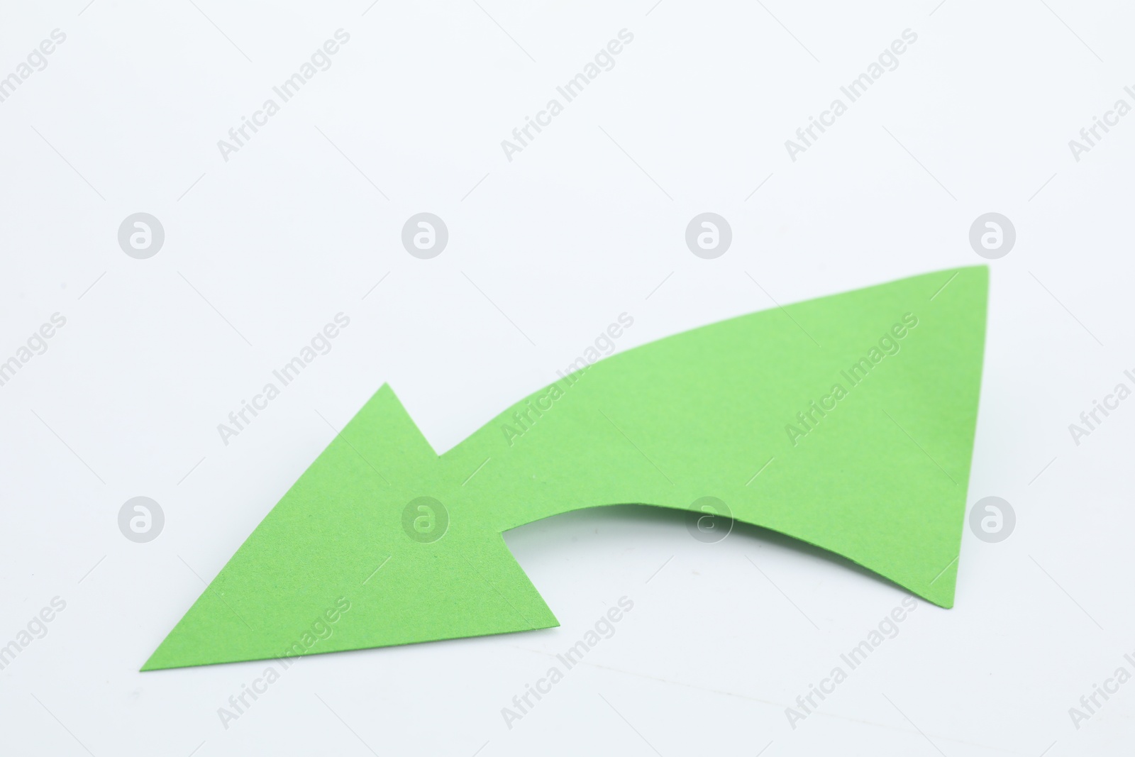 Photo of One green paper arrow isolated on white