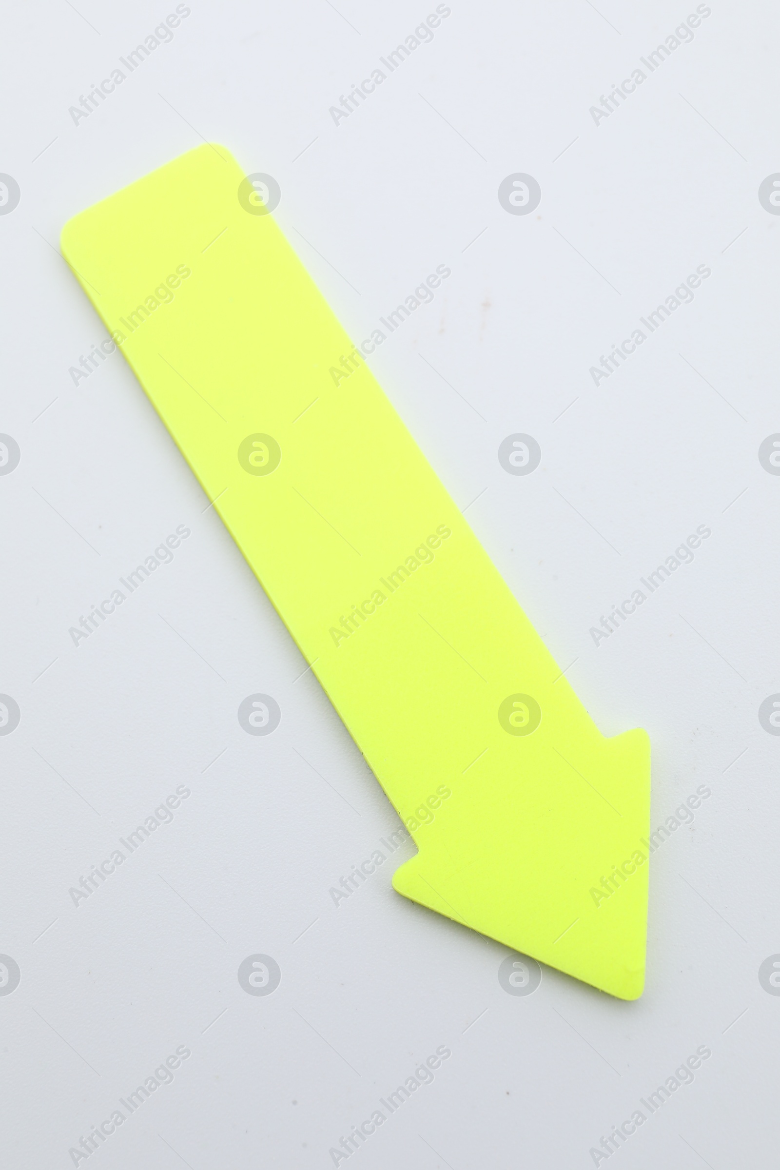 Photo of One yellow paper arrow isolated on white, top view