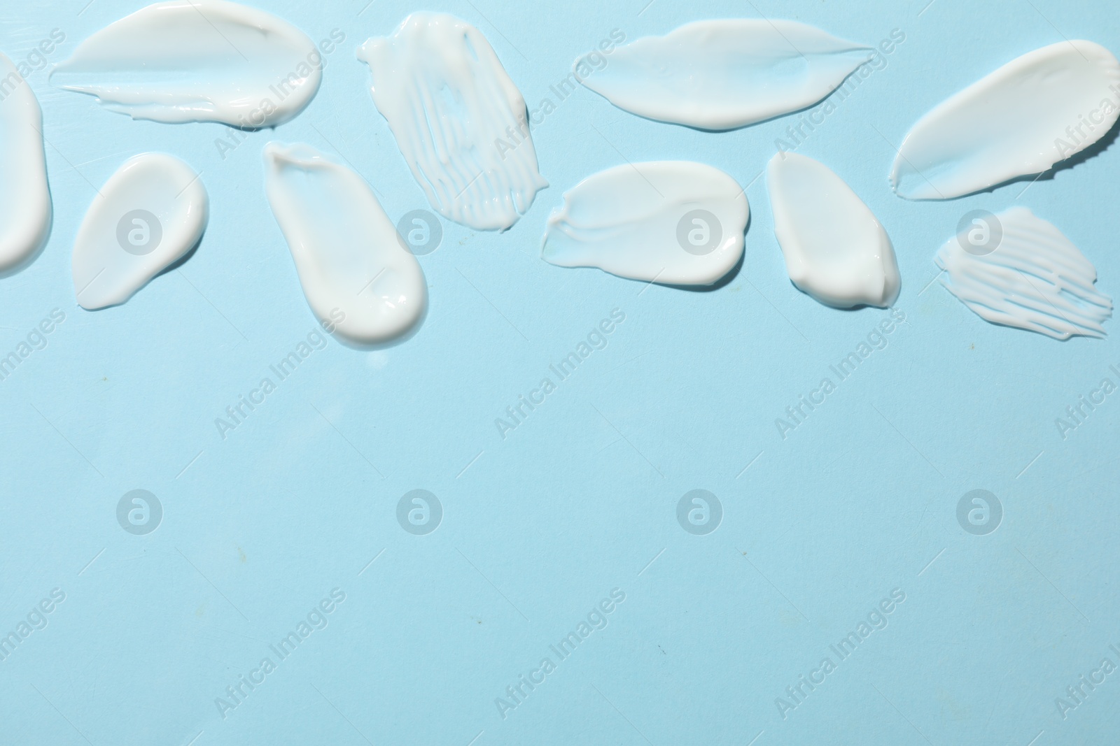 Photo of Body cream on light blue background, flat lay. Space for text