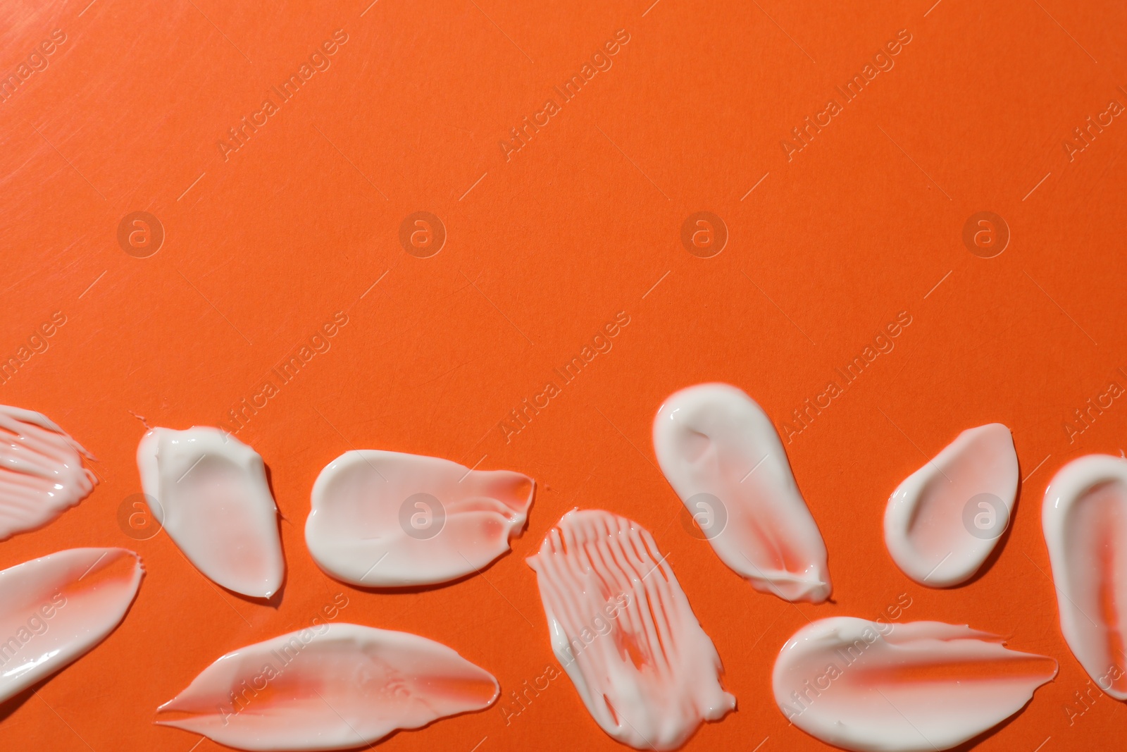 Photo of Body cream on orange background, flat lay. Space for text