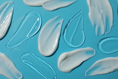 Photo of Body cream and gel on light blue background, flat lay