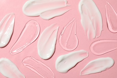 Photo of Body cream and gel on pink background, flat lay