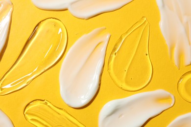 Photo of Body cream and gel on yellow background, flat lay