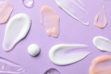 Photo of Different cosmetic products on violet background, flat lay