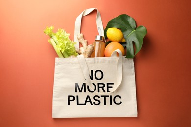 Image of Eco bag with No More Plastic text and products on orange background, top view