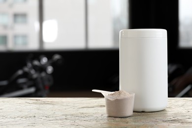 Protein powder on table in gym, space for text