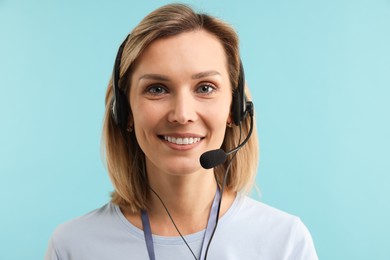 Photo of Technical support call center. Portrait of smiling operator on light blue background