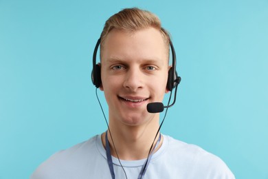 Photo of Technical support call center. Portrait of smiling operator on light blue background