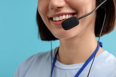 Photo of Technical support call center. Smiling operator on light blue background, closeup