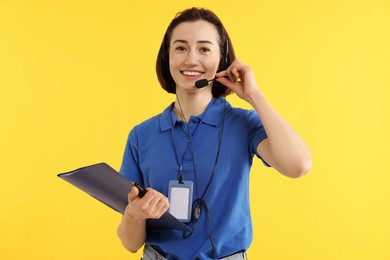 Photo of Technical support call center. Smiling operator with folder on yellow background