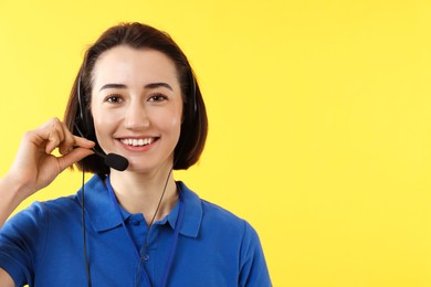 Photo of Technical support call center. Smiling operator on yellow background. Space for text